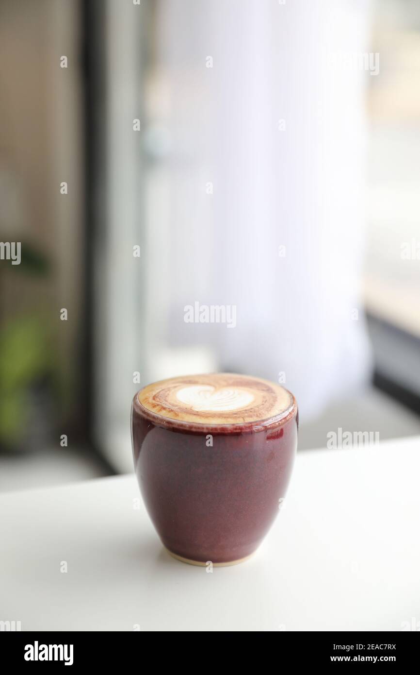 Cappuccino oder Latte Art Kaffee aus Milch auf dem Holz Tisch im Café Stockfoto