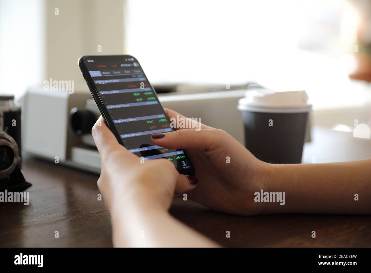 Weibliche hand mit Smartphone Handel Börse online im Coffee Shop, Business Konzept Stockfoto