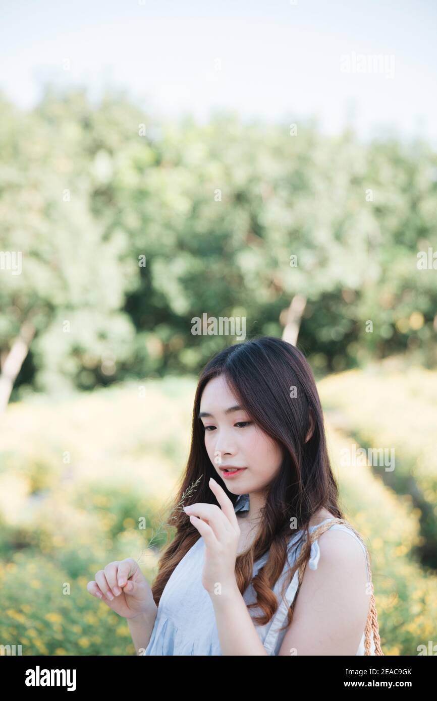 Portrait von jungen asiatischen frau mädchen lächeln im Blumengarten Stockfoto