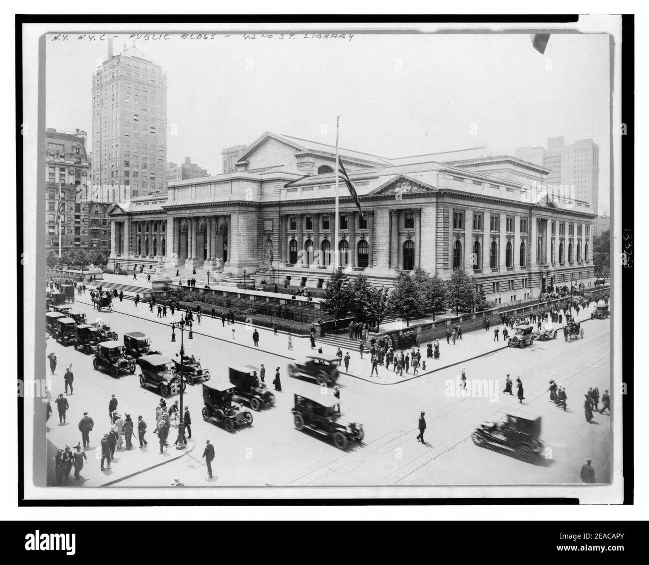 New York Public Library vom Gebäude auf der Kreuzung von E. 42nd Street und Fifth Avenue gesehen, Anzeigen vorne und Osten Fassaden, sowie Automobil- und Fußgängerverkehr Stockfoto