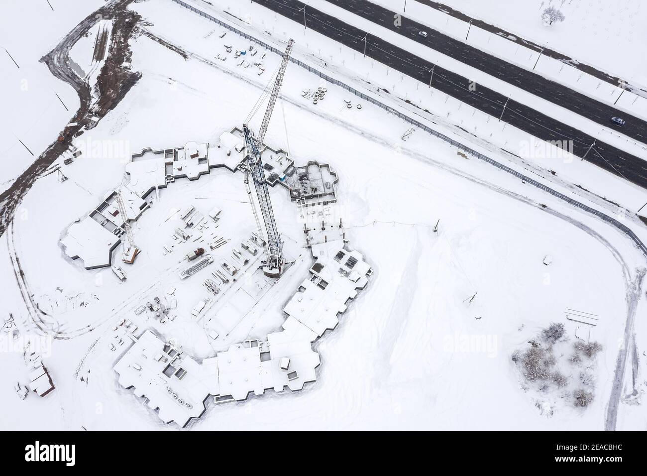 Baustelle im Winter. Bau eines modernen Wohnkomplexes in einem Vorort. Luftaufnahme Stockfoto