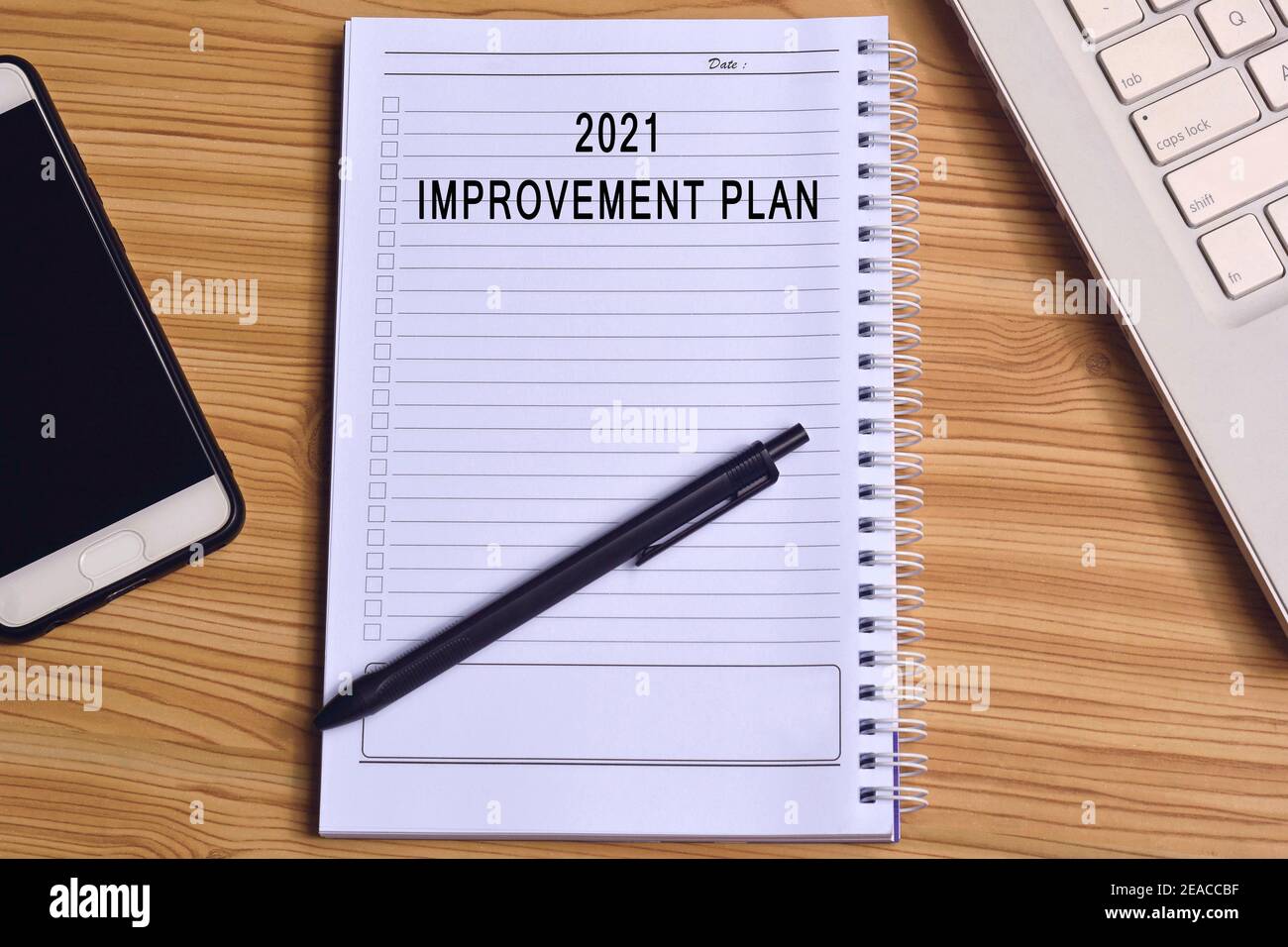 Text auf Notizblock mit Laptop und Smartphone auf Holztisch Stockfoto