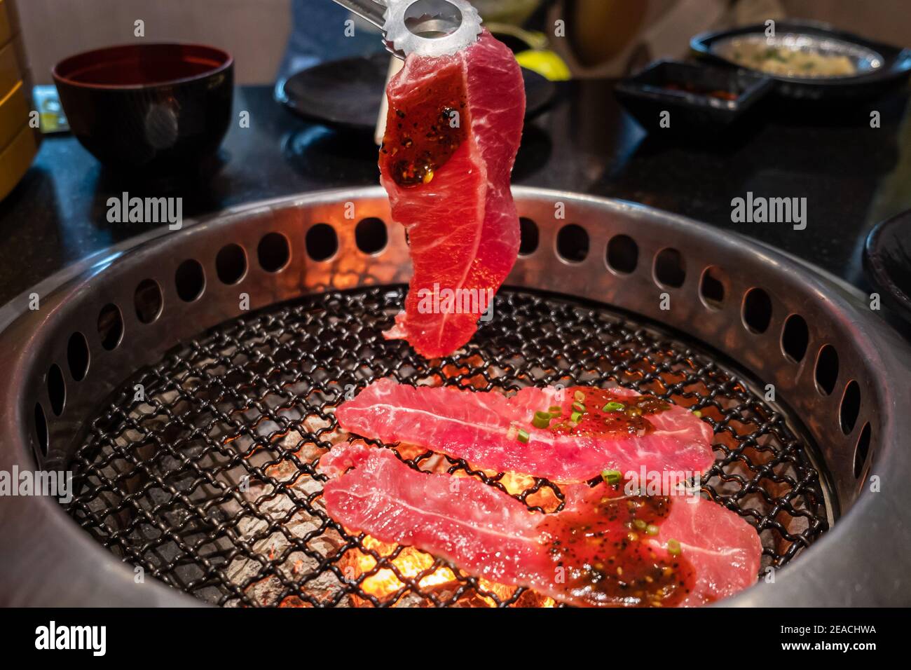 Nahaufnahme rohes Rindfleisch Scheibe auf dem Grill, über Holzkohle auf Herd, japanische Stil Yakiniku. Stockfoto