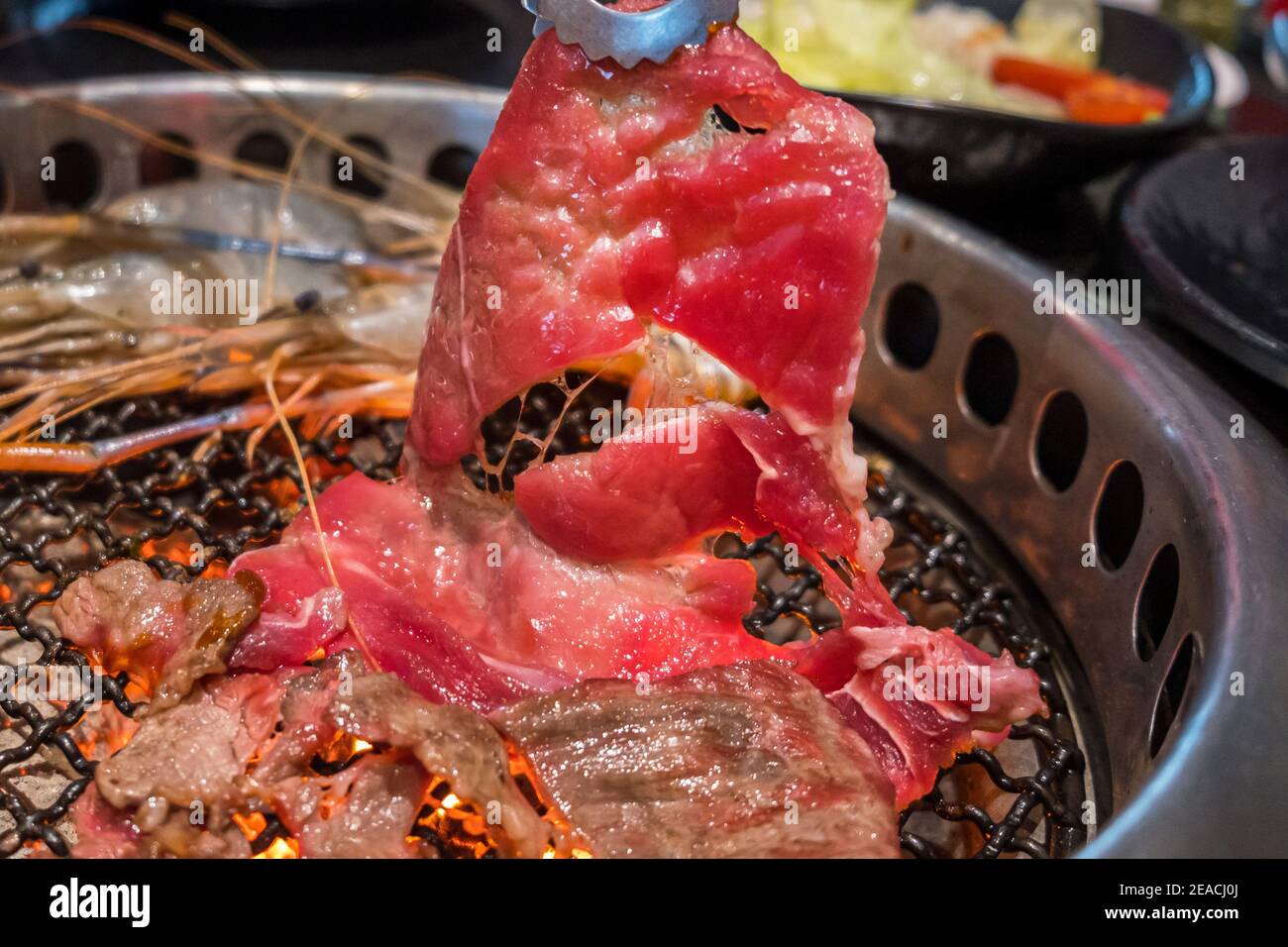Nahaufnahme rohes Rindfleisch Scheibe auf dem Grill, über Holzkohle auf Herd, japanische Stil Yakiniku. Stockfoto