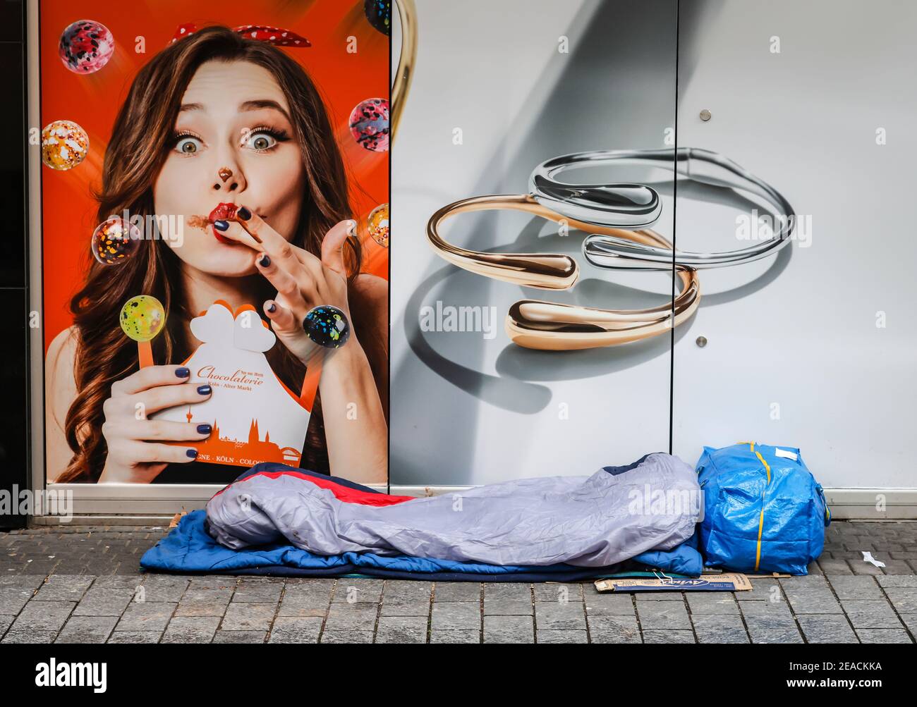 Köln, Nordrhein-Westfalen, Deutschland - Kölner Innenstadt in Zeiten der Coronakrise während der zweiten Sperre sind die Geschäfte geschlossen, ein Obdachloser schläft auf der Straße. Stockfoto