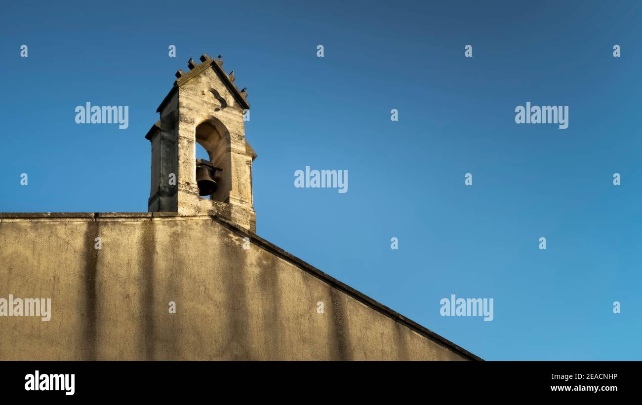 Glockenturm der Kirche Notre Dame in Coursan. Monument historique, das älteste Gebäude im Dorf. Stockfoto