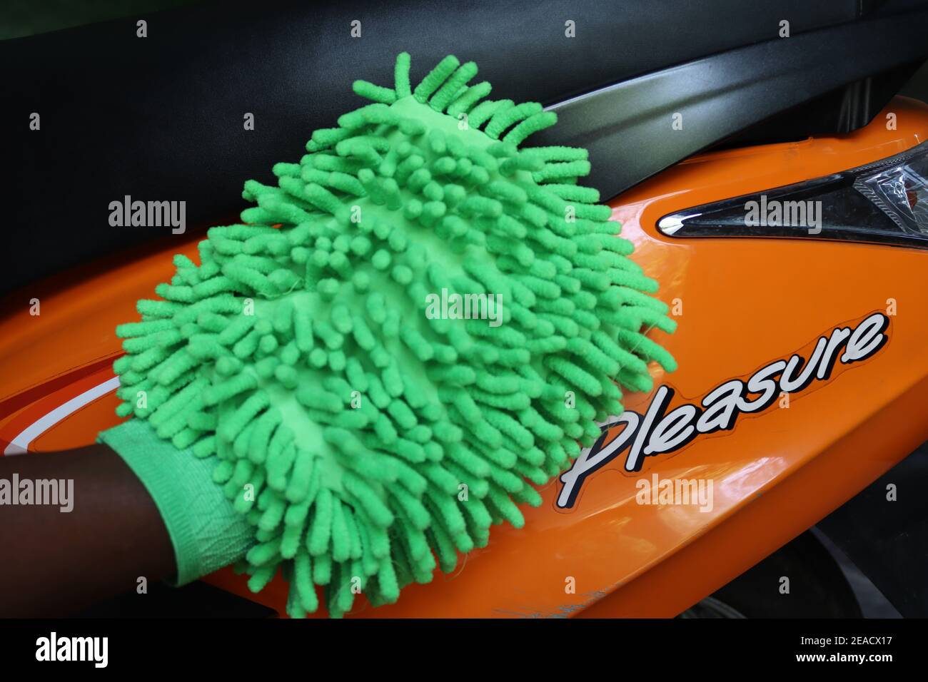 Wischen einer Seitenabdeckung eines indischen Roller mit einem Mikro-Reiniger und die Aufgabe zeigt uns eine andere Farbe auf dem Foto, (tägliche Aktivitäten) Stockfoto