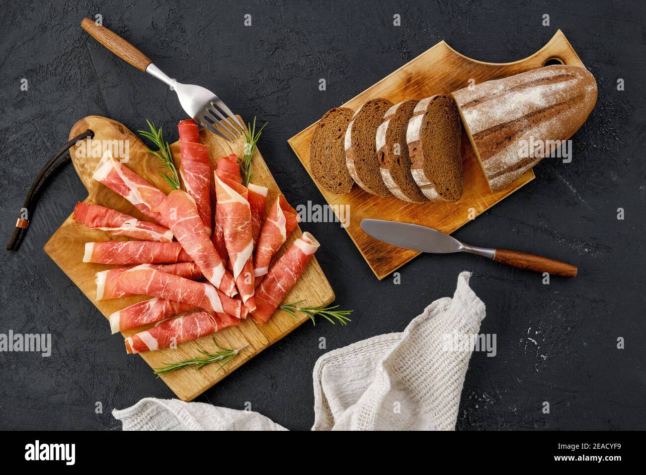 Draufsicht auf gerollte Scheiben von Jamon auf Holzschnitt Platine Stockfoto