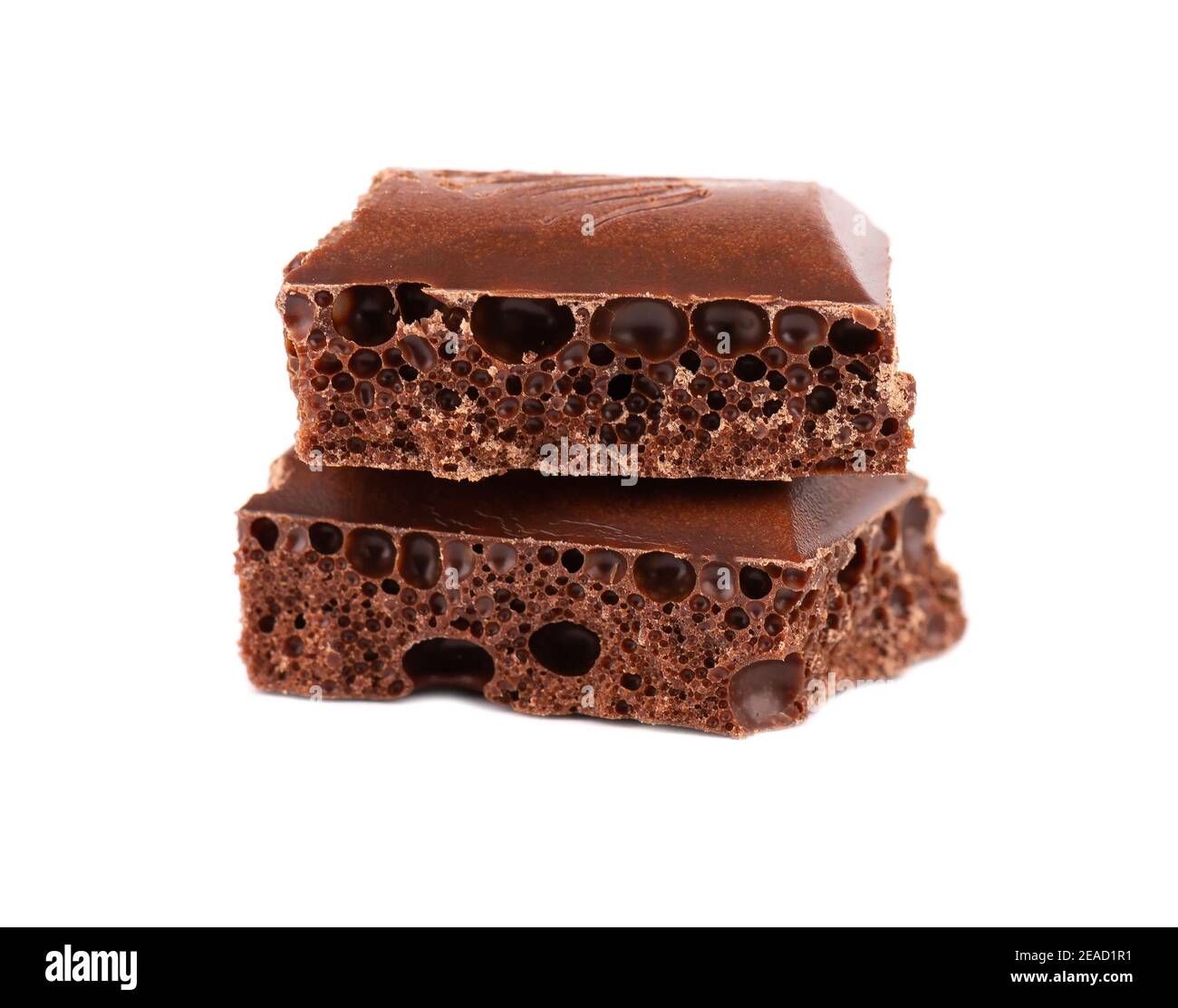 Poröse Schokoladenstücke isoliert auf weißem Hintergrund. Schwarze, belüftene Schokolade. Stockfoto