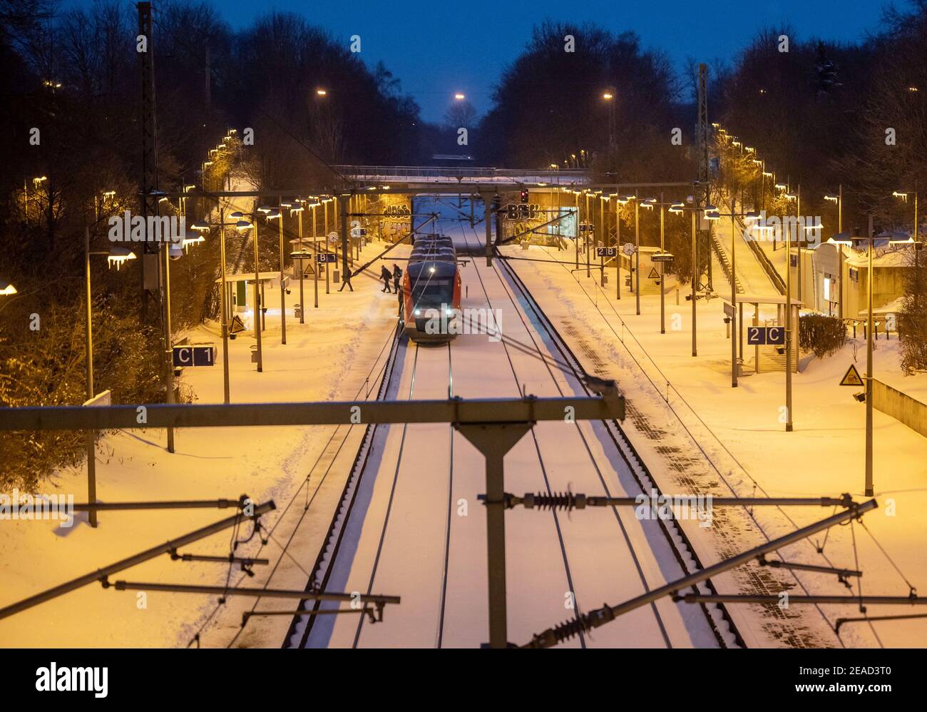 Dortmund, Deutschland. Februar 2021, 09th. Ein paar Fahrgäste steigen am Bahnhof Signal-Iduna-Park auf einer schneebedeckten Plattform früh am Morgen aus. Lautsprecherdurchsagen zeigten auch an, dass Züge aufgrund des Wetters abgesagt würden. Quelle: Bernd Thissen/dpa/Alamy Live News Quelle: dpa picture Alliance/Alamy Live News Stockfoto