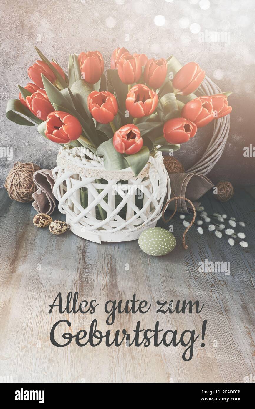 Text alles gute zum Geburtstag bedeutet Happy Birthday auf Deutsch. Bündel  von roten Blumen in wattle Rattan Holzvase auf rustikalen Holztisch mit  Muschi Stockfotografie - Alamy