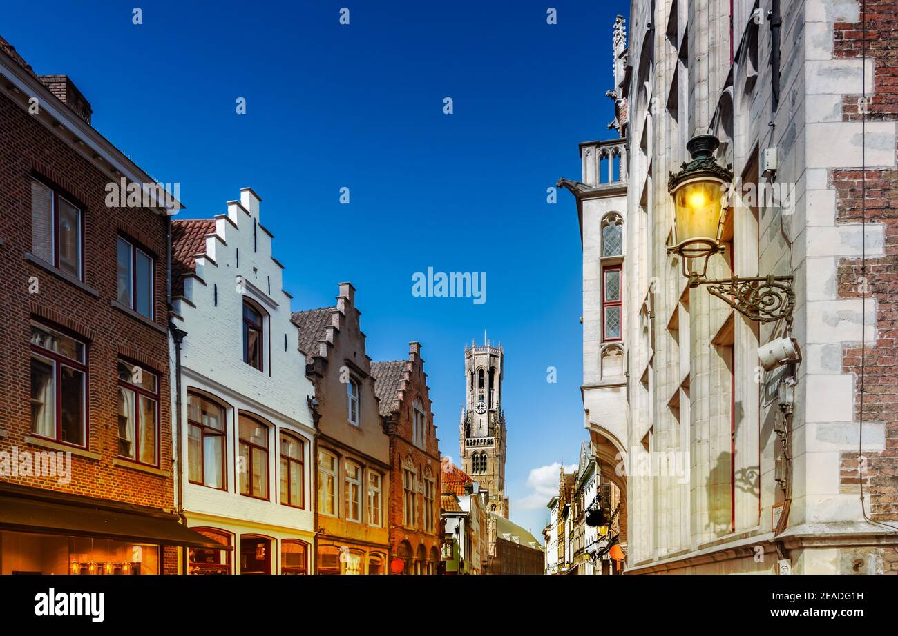 Brügge, Belgien. Stadtbild mit traditionellen Häusern und mittelalterlichen Glockenturm Glockenturm Belfried in der Innenstadt in der Dämmerung. Stockfoto
