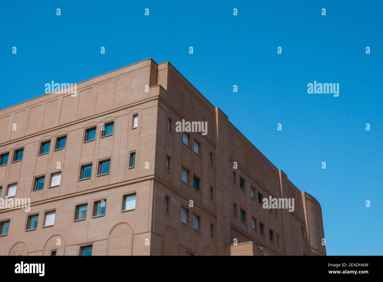 Gewöhnliches Bürogebäude aus rotem Backstein mit perfektem blauen Himmel Der Hintergrund Stockfoto