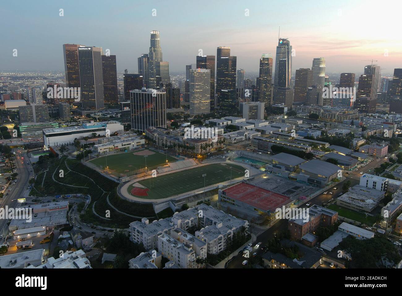 Eine Luftaufnahme des Miguel Contreras Learning Center-Academic Leadership Community High School mit der Innenstadt von Los Angeles Skyline AS Ein Hintergrund o Stockfoto