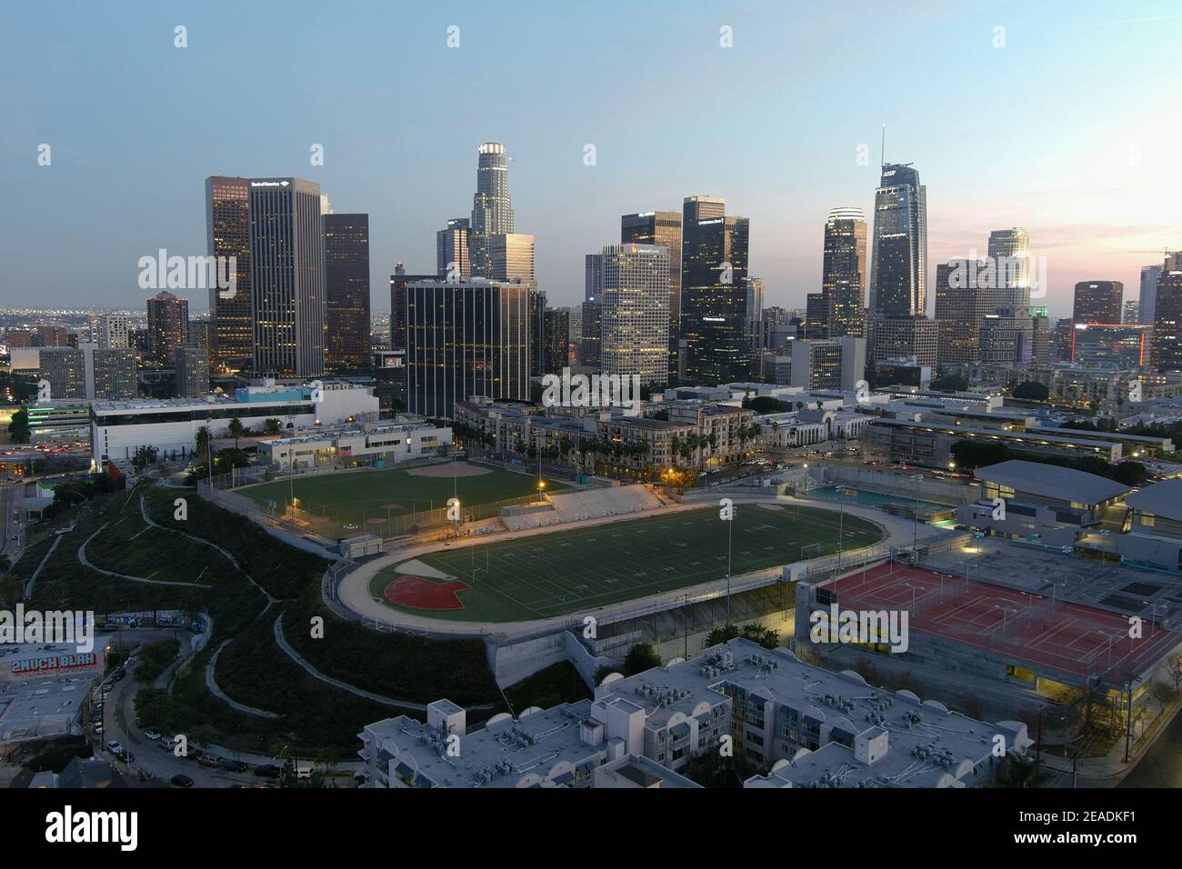 Eine Luftaufnahme des Miguel Contreras Learning Center-Academic Leadership Community High School mit der Innenstadt von Los Angeles Skyline AS Ein Hintergrund o Stockfoto