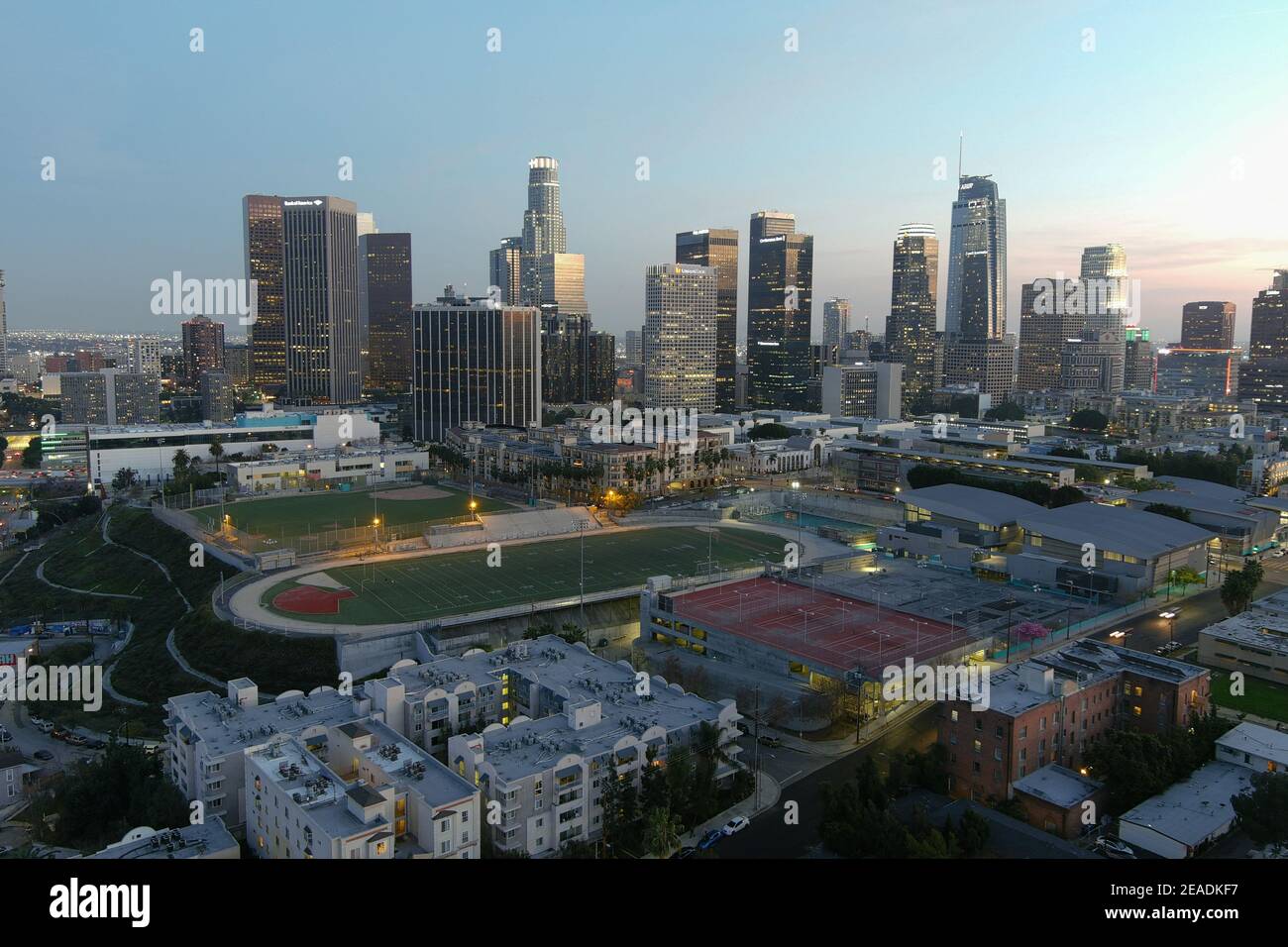 Eine Luftaufnahme des Miguel Contreras Learning Center-Academic Leadership Community High School mit der Innenstadt von Los Angeles Skyline AS Ein Hintergrund o Stockfoto