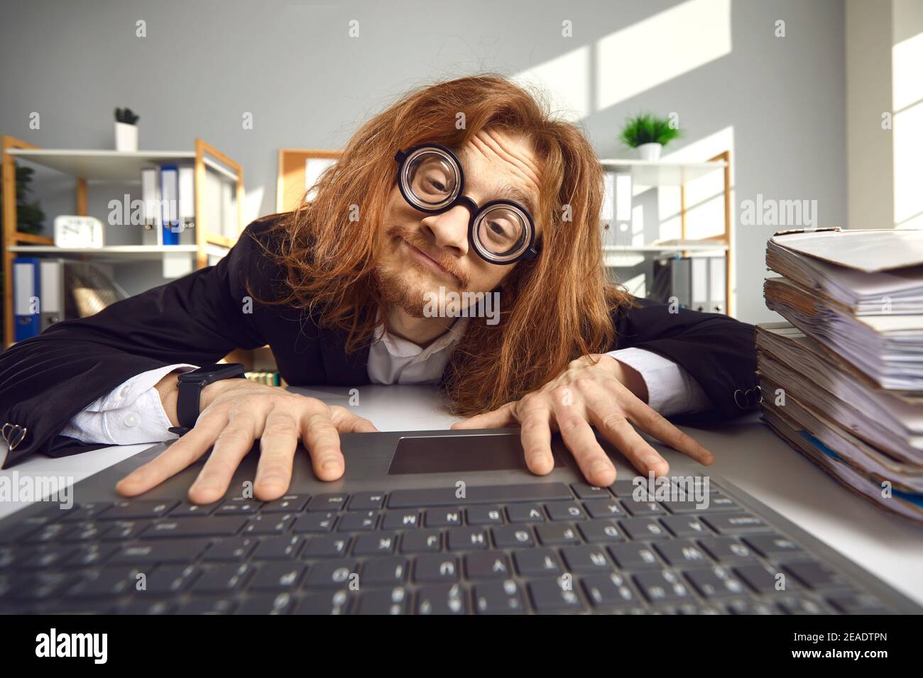 Lustiger Nerd in der Brille mit Laptop und die Suche nach Informationen Im Internet Stockfoto
