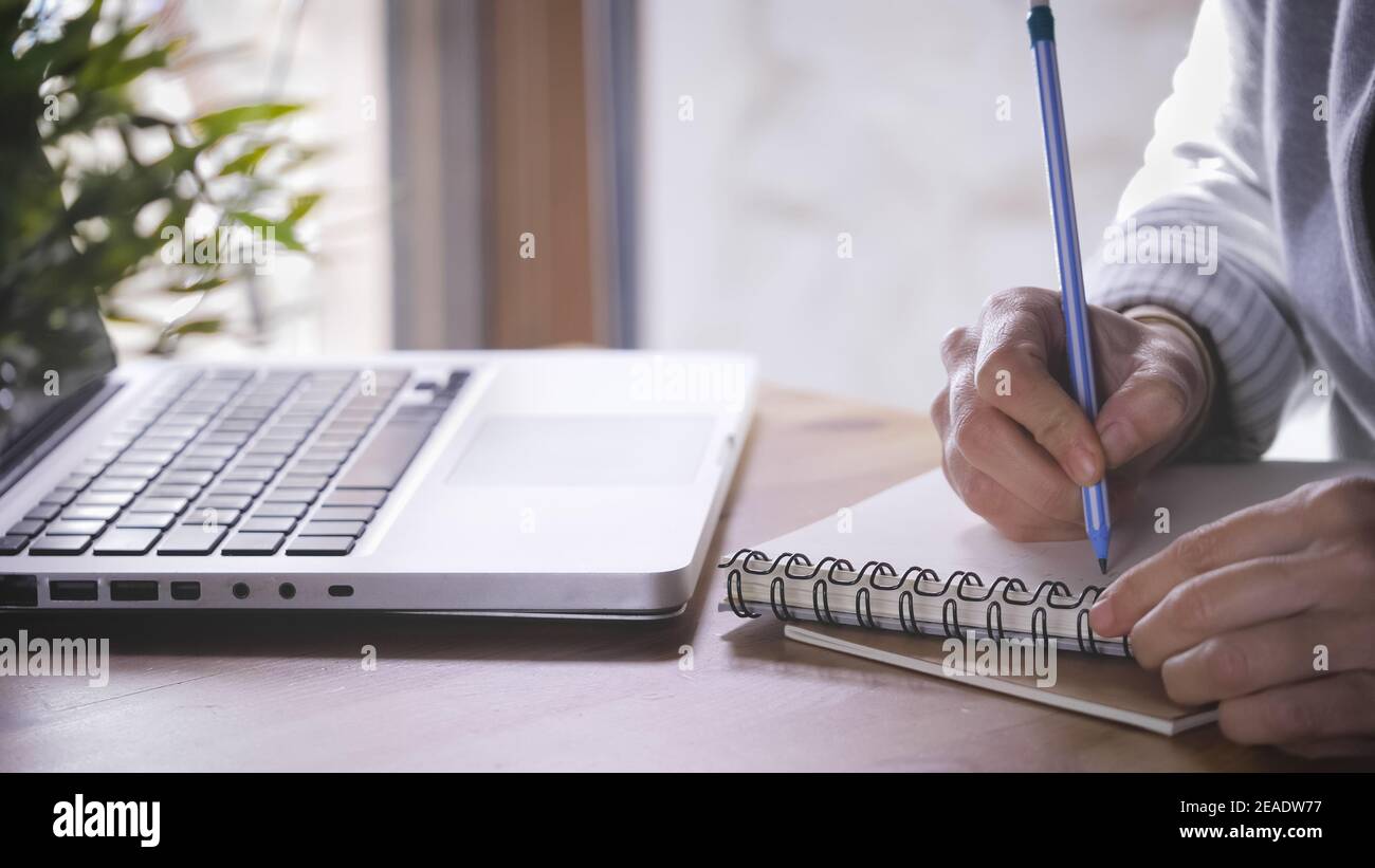 Arbeiten zu Hause, smart arbeiten. Frau ist eingestellt und schreibt auf Notebook, Laptop ist auf dem Schreibtisch. Mädchen verwendet mehr technologische Gerät für die Kommunikation und Stockfoto