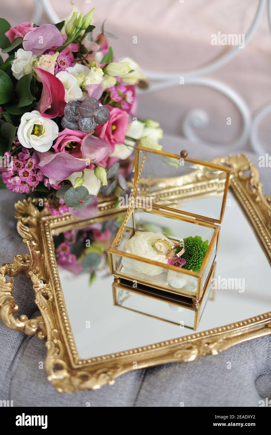 Eheringe in einer dekorativen Glasbox mit Blumen Stockfoto