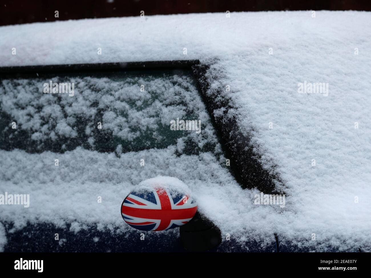 Coalville, Leicestershire, Großbritannien. 9th. Februar 2021. Wetter in Großbritannien. Ein Mini CooperÕs-Spiegel mit einer Union-Flagge ist aus dem Schnee herausragen. Credit Darren Staples/Alamy Live News. Stockfoto
