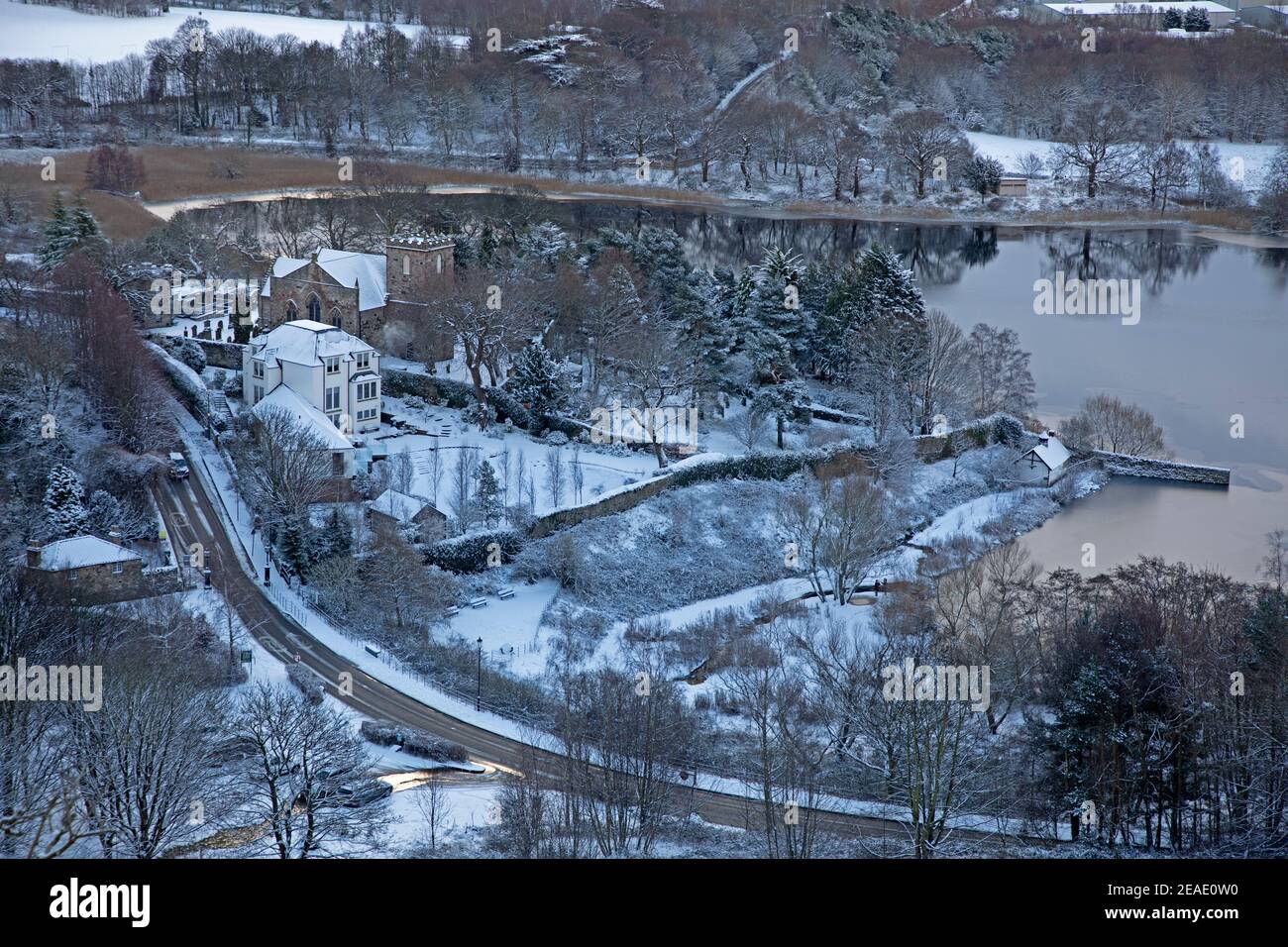 Holyrood Park Edinburgh, Schottland, Großbritannien. 9th. Februar 2021. Der schneebedeckte Holyrood Park ermutigte die Leute, zwischen den Duschen zu spielen und zu trainieren. Im Bild: Duddingston Loch und Kirk hübsch als Bild im Schnee. Stockfoto