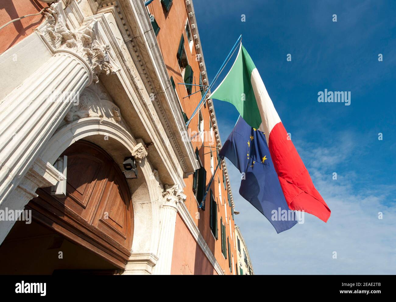 Flaggen, die vor einem Gebäude auf dem Markusplatz in Venedig, Italien, fliegen. Stockfoto