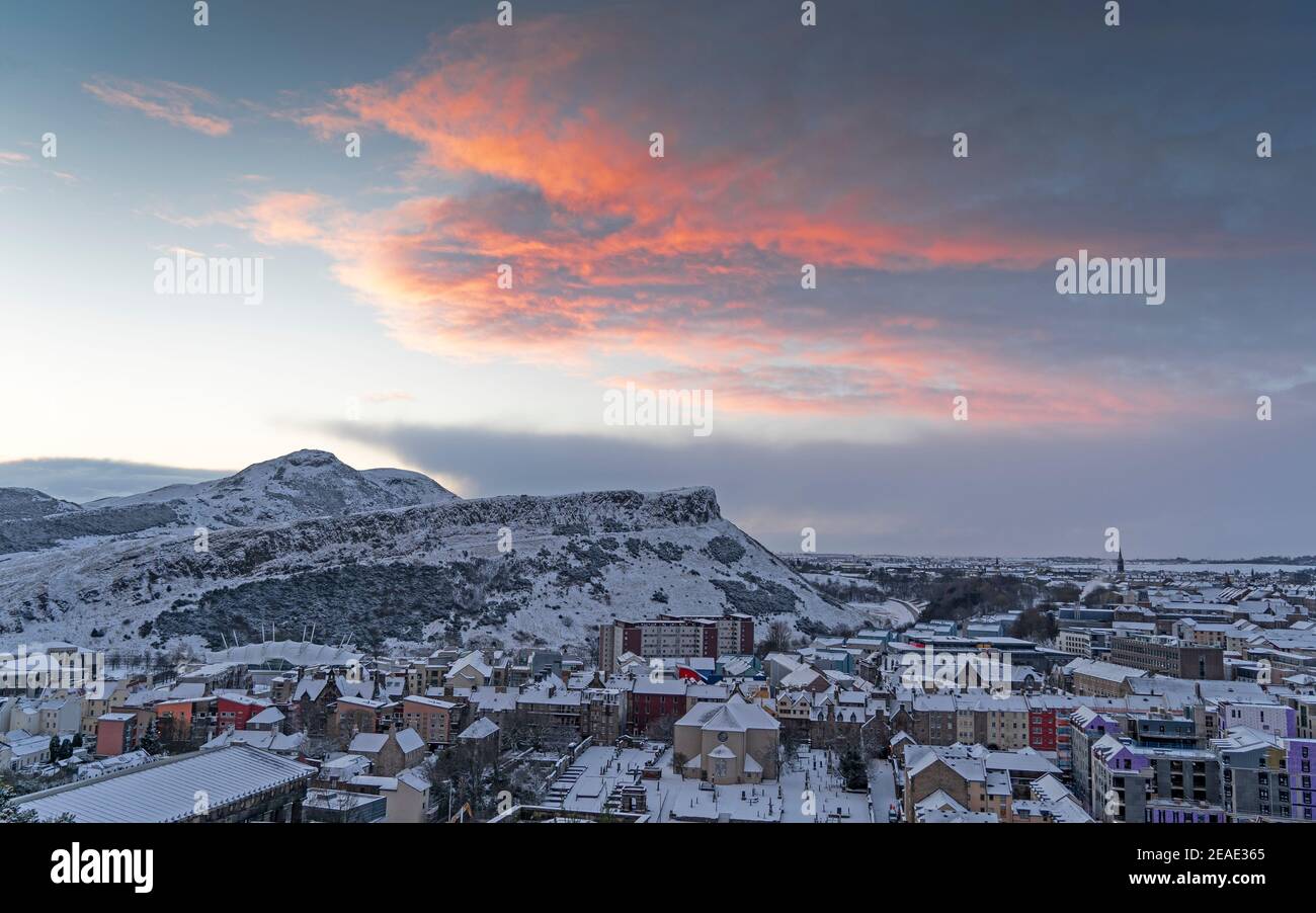 Edinburgh, Schottland, Großbritannien. Februar 2021, 9. Der große Frost geht in Großbritannien weiter, während Storm Darcy über Nacht mehrere Zentimeter Schnee nach Edinburgh bringt. Bild: Roter Himmel bei Sonnenaufgang über Arthurs Seat und Salisbury Crags. Iain Masterton/Alamy Live Nachrichten Stockfoto