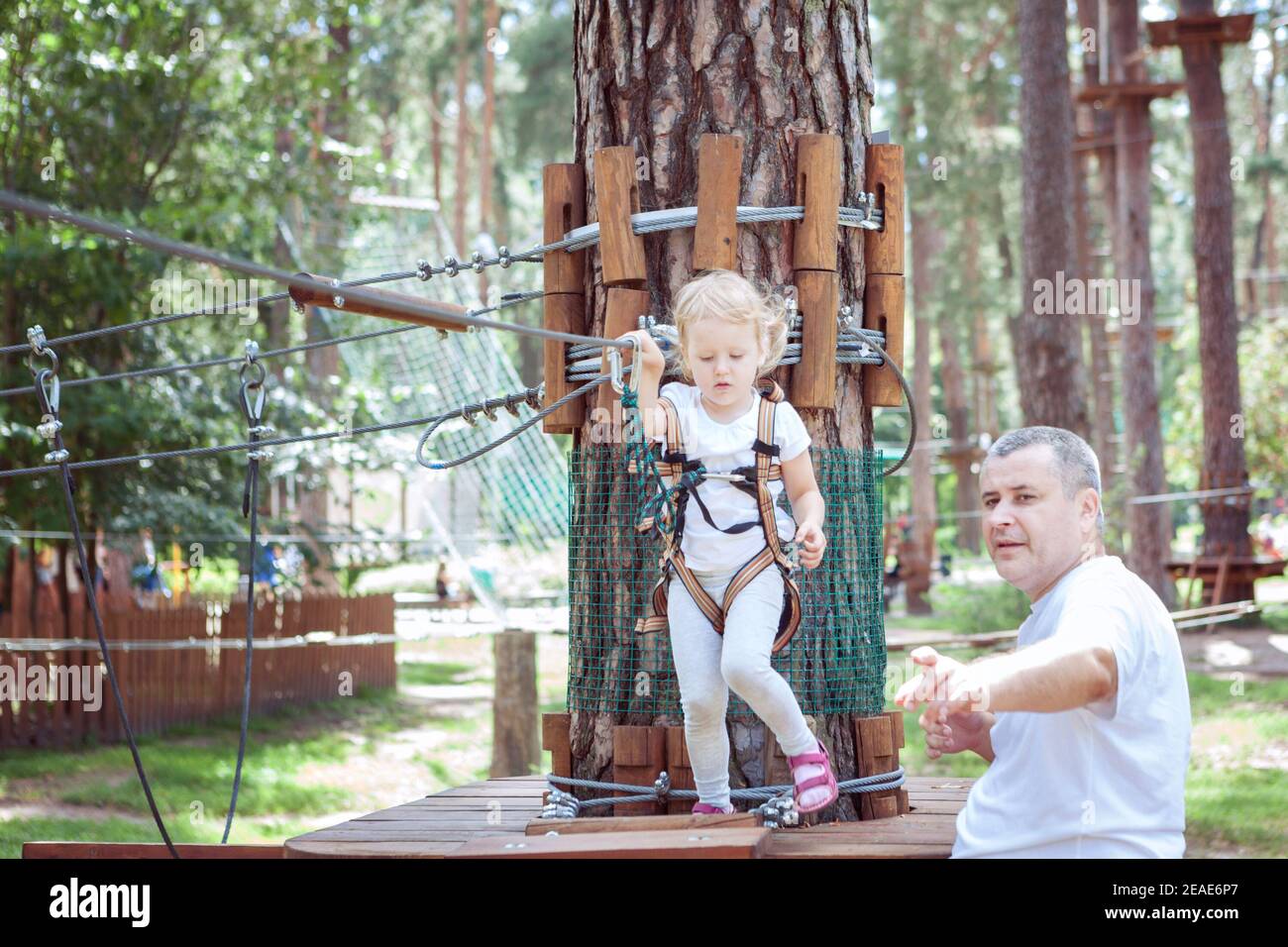 Junger Vater lehrt seine Tochter, Hindernisse in einem passieren Vergnügungspark Stockfoto