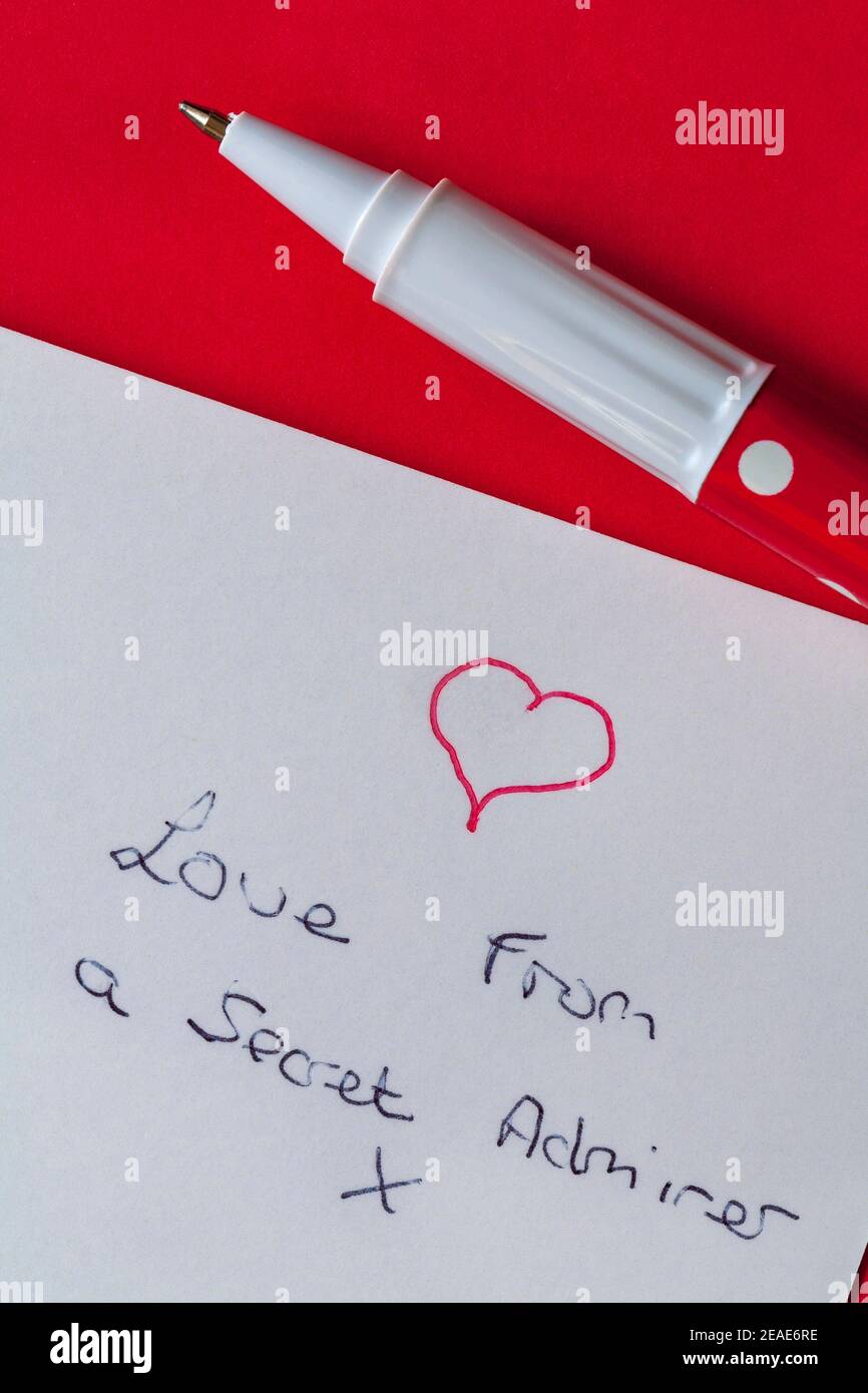 Liebe aus einer geheimen Bewunderer-Hand mit Herz in Karte mit Stift für Valentinstag, Valentinstag geschrieben - Nahaufnahme Detail Stockfoto