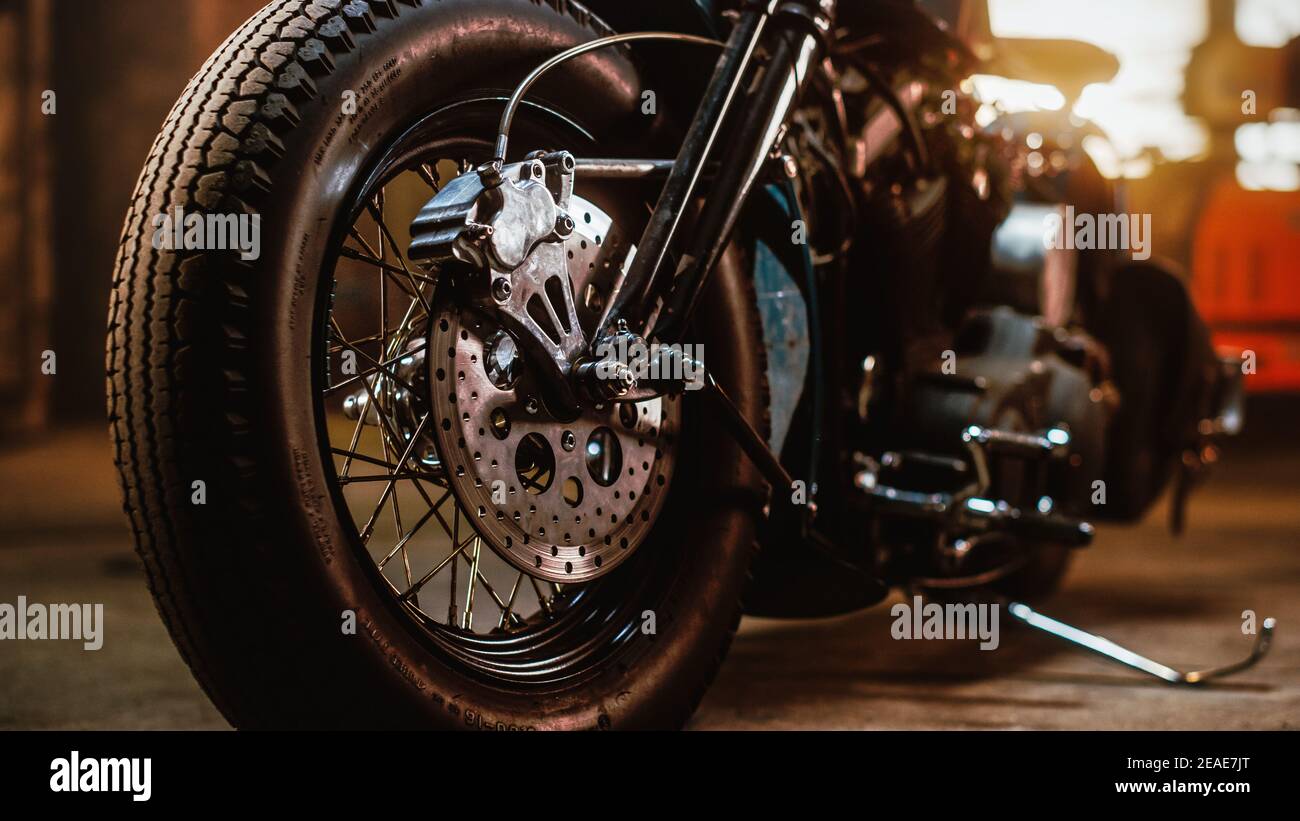 Makro Close Up Wheel Details eines Custom Bobber Motorrads stehen in einem authentischen kreativen Workshop. Verchromte Motorradspeichen und Scheibenbremsen Stockfoto