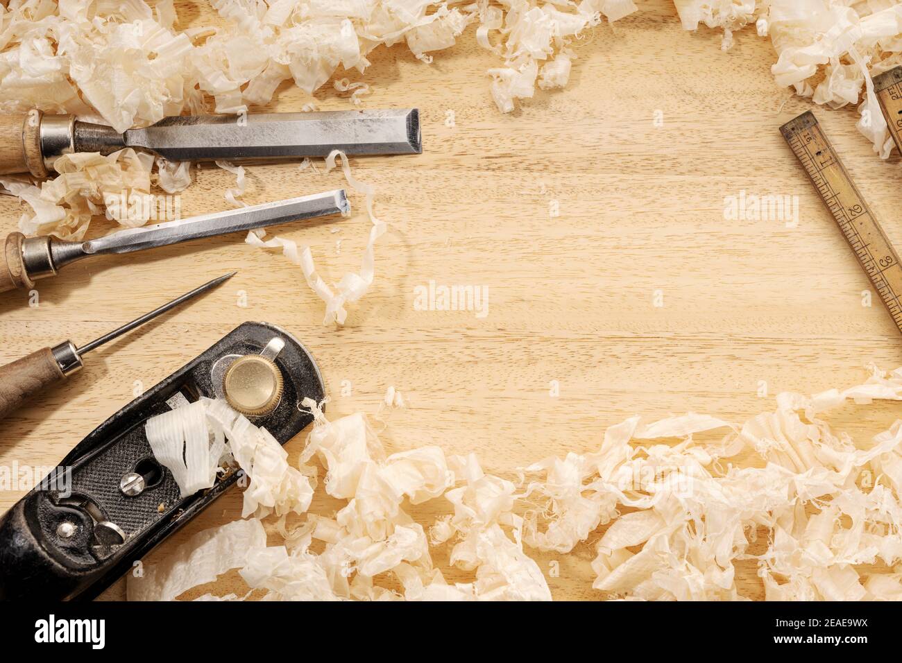 Schreinerei oder Holzbearbeitung Hintergrund mit Kopierraum. Alte Schreinerei Werkzeuge und Holzspäne auf einer Werkbank. Holzbearbeitung, Handwerk und Handarbeit con Stockfoto
