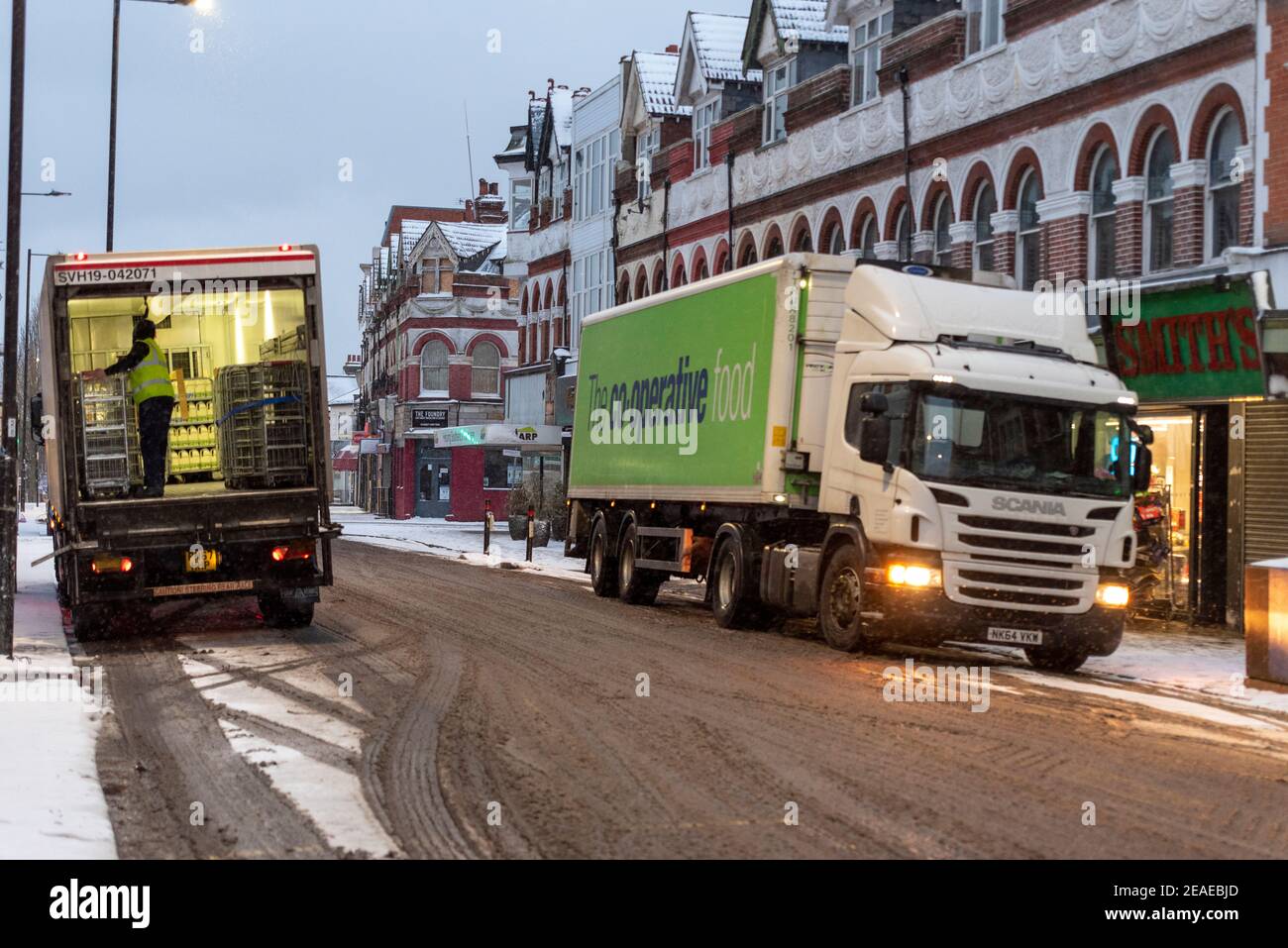 Westcliff on Sea, Essex, Großbritannien. Februar 2021, 9th. Storm Darcy hat weiteren Schnee fallen gelassen, und brachte eisige und windige Bedingungen. Wiederbelegung Co-op Supermarkt in Hamlet Court Road, Westcliff on Sea. Schlüsselarbeiter Entladen der Lieferung Stockfoto