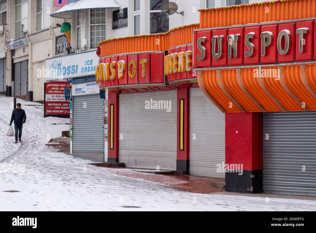 Southend on Sea, Essex, Großbritannien. Februar 2021, 9th. Storm Darcy hat an der Strandpromenade weiteren Schnee fallen gelassen und eisige und windige Bedingungen gebracht. Jogger und Spaziergänger trotzten der Kälte und Winden entlang der Küste, vorbei an geschlossenen Unternehmen und Spielhallen Stockfoto