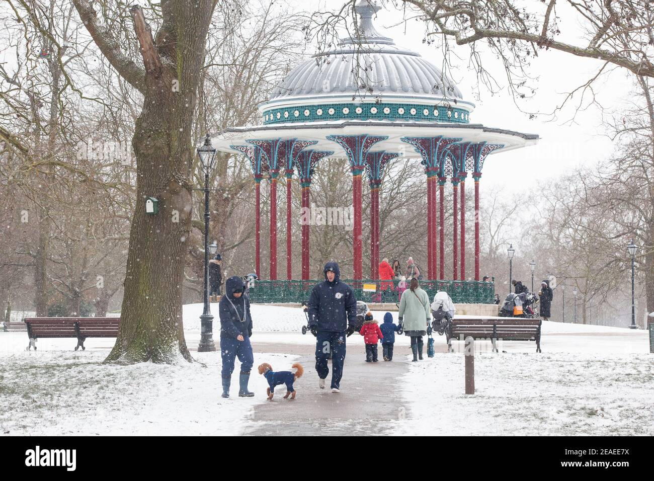 London, Großbritannien. 9. Februar 2021: Nach drei Tagen Schnee in London beginnt es sich zu beruhigen und die Winde sind gefallen, als Storm Darcy vorbei ist. Auf Clapham Common trainieren einige Leute mit ihren Kindern oder Hunden in der Nähe des Bandstandens. Anna Watson/Alamy Live News Stockfoto