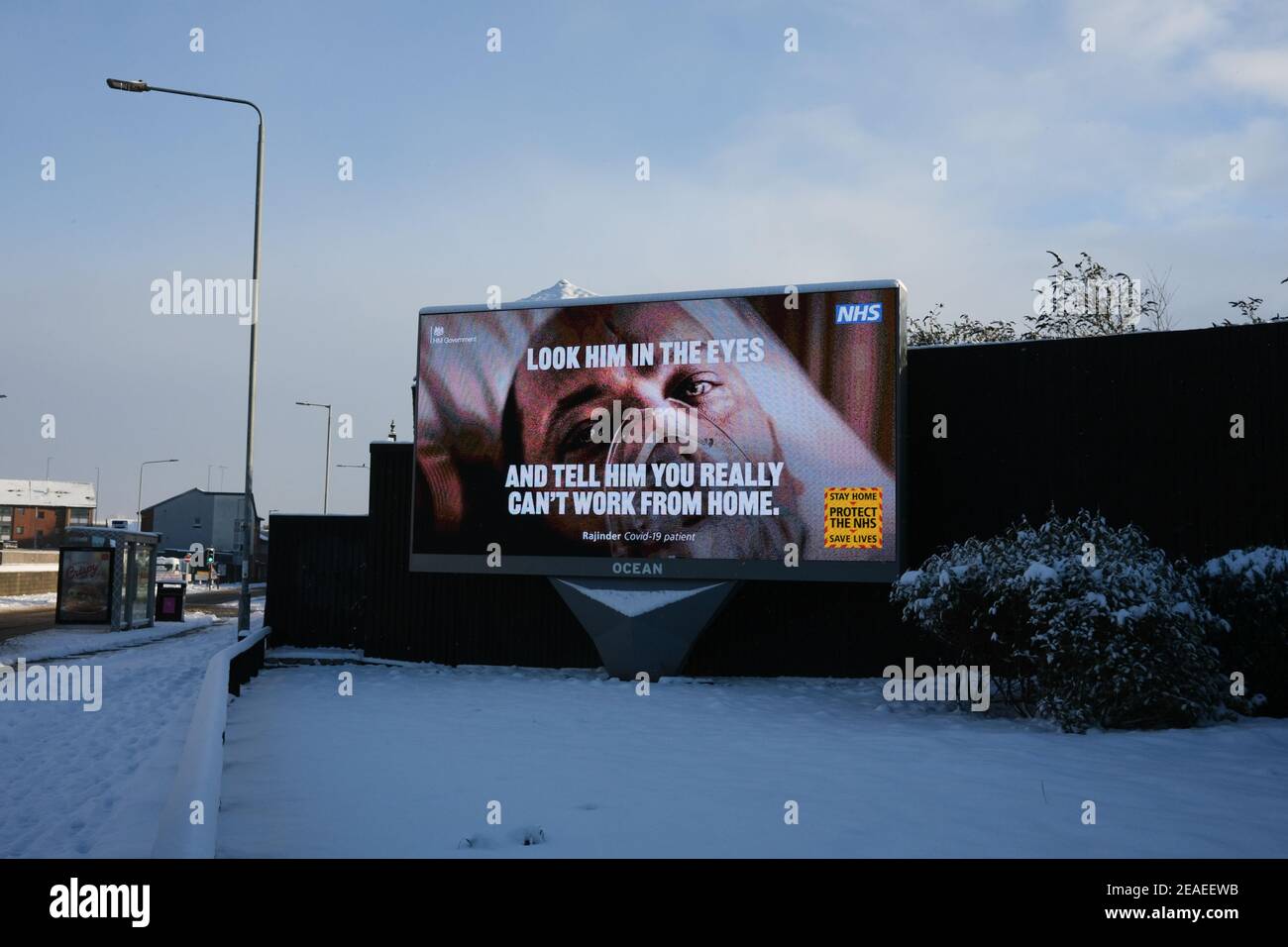 Glasgow, Großbritannien, am 9. Februar 2021. Öffentliche Informationsanzeigen spielen auf einer elektronischen Plakatwand, auf einer verlassenen Straße, nach dem Schneehön der Vornacht. Glasgow bleibt während der laufenden Covid-19-Coronavirus-Gesundheitspandemie weiterhin in der Sperre. Foto: Jeremy Sutton-Hibbert/ Alamy Live News. Stockfoto