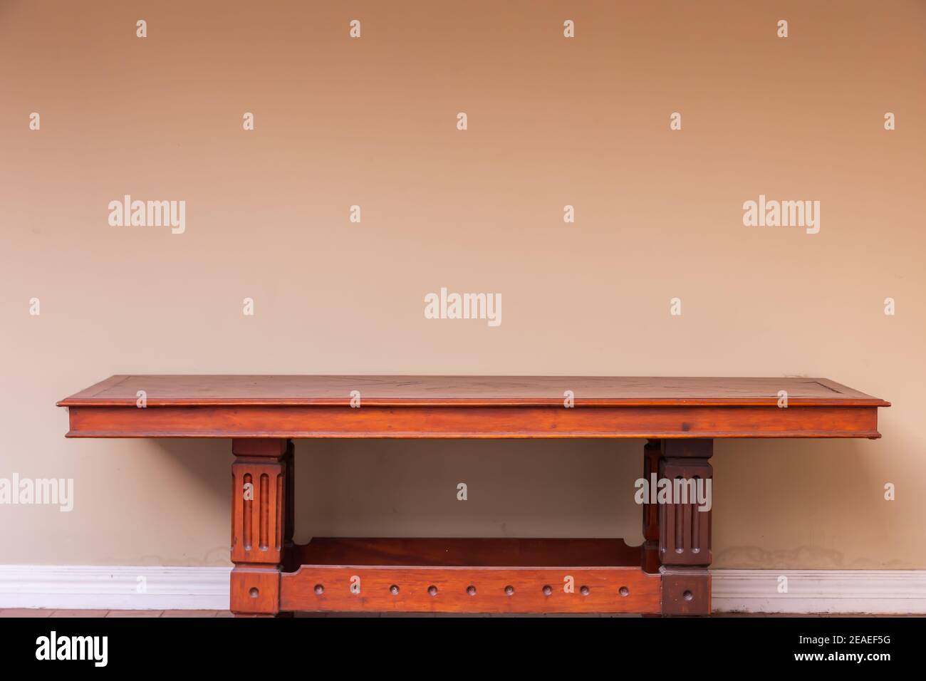 Leerer Holztisch aus Hartholz und Wandhintergrund. Stockfoto
