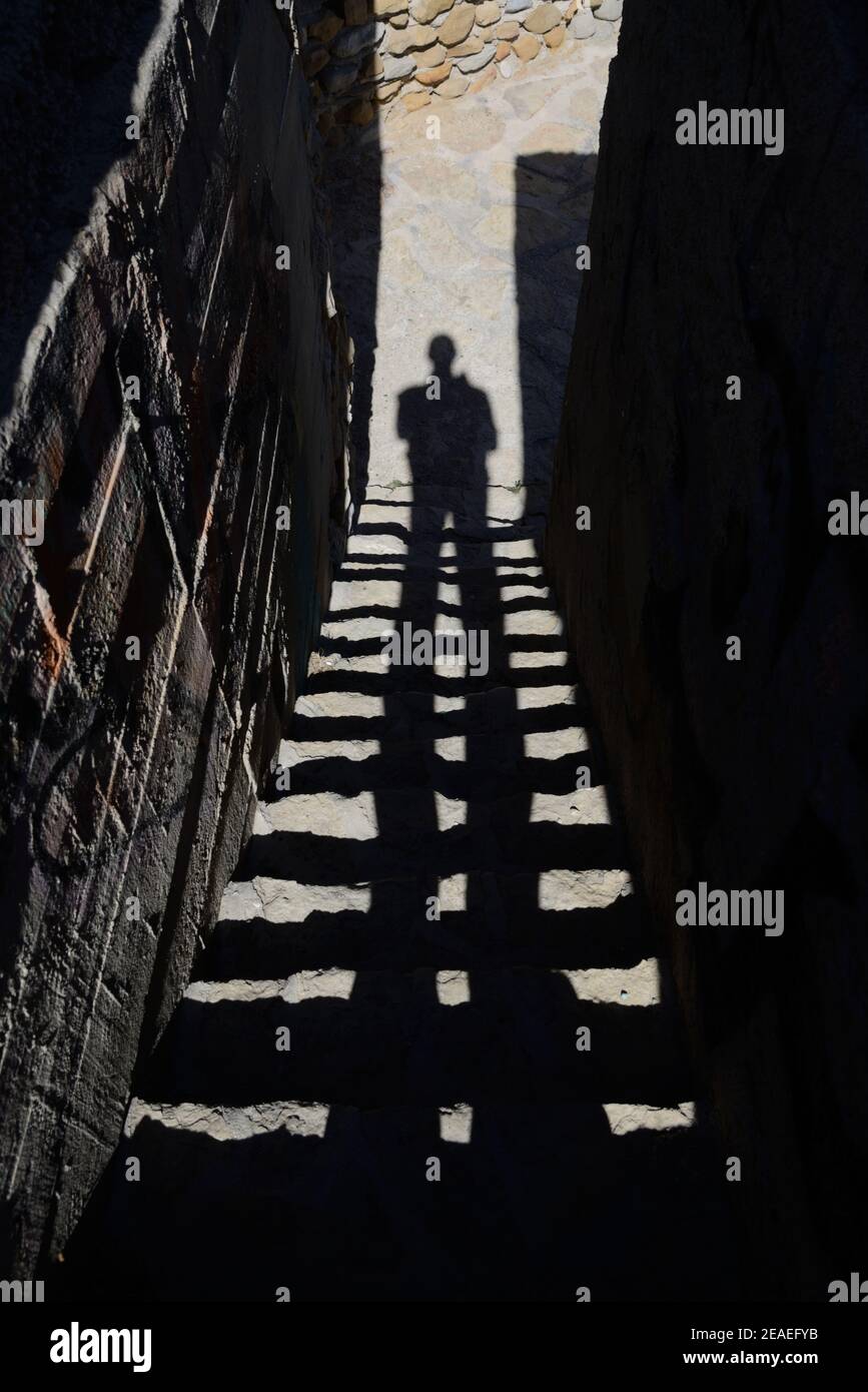 Geheimnisvolles Bild des langen Schattens des Menschen auf Treppen, Stufen oder Treppen in der dunklen, schmuddeligen Gasse oder Gasse Stockfoto