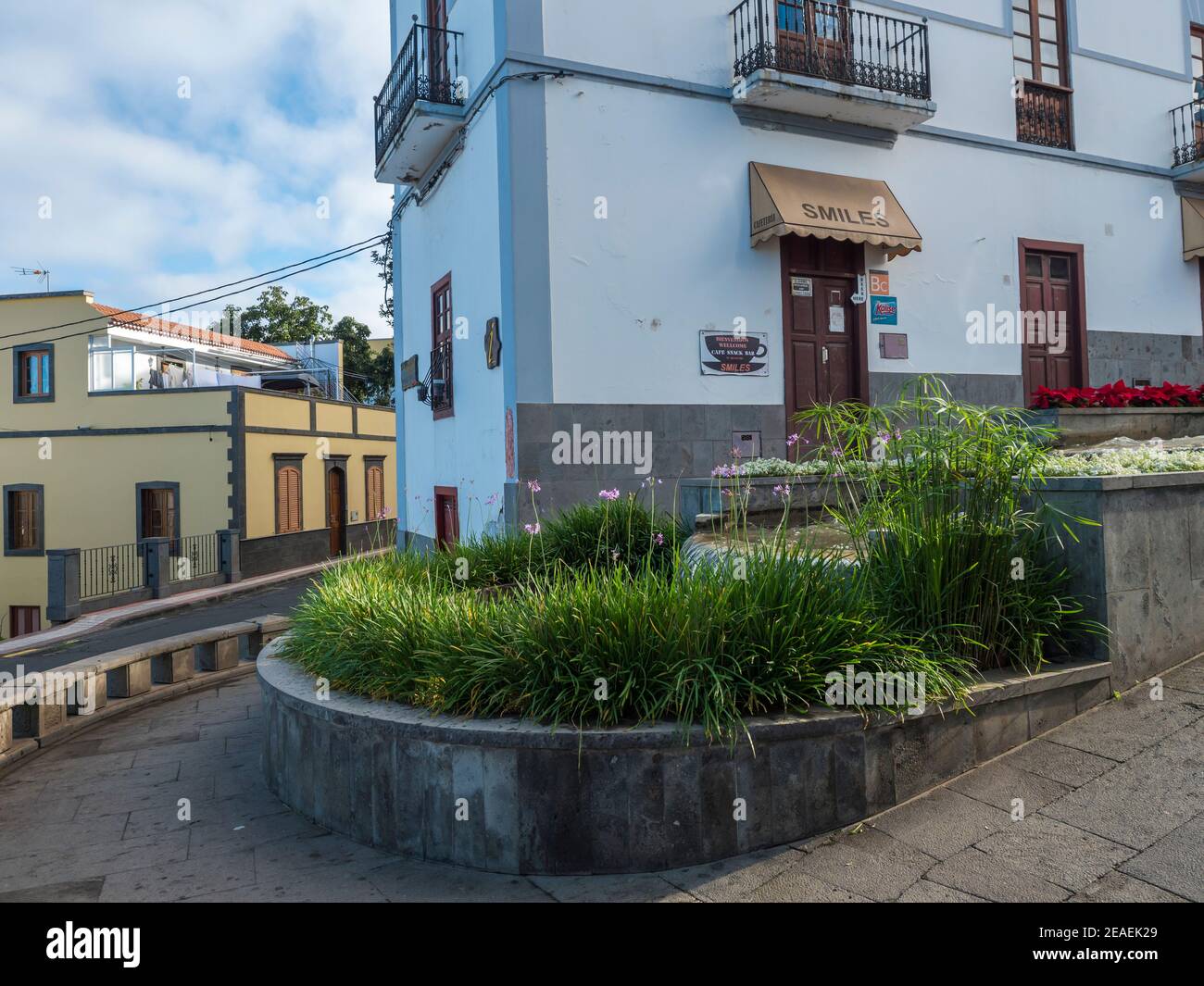 Firgas, Gran Canaria, Kanarische Inseln, Spanien 13. Dezember 2020: Blick auf die Straße Paseo de Gran Canaria mit Wasserfall Brunnen, Blumen und Keramik Stockfoto