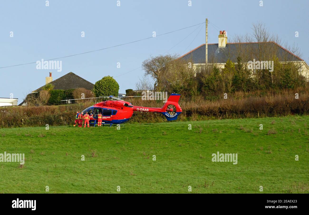 Devon Air Ambulance Hubschrauber in einem Feld neben Häusern. Stockfoto