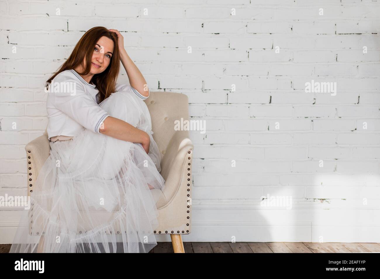 Verärgert Frau im Rock tutu weinen besorgt über Problem sitzen Auf einem Sessel im weißen Loft-Zimmer Stockfoto