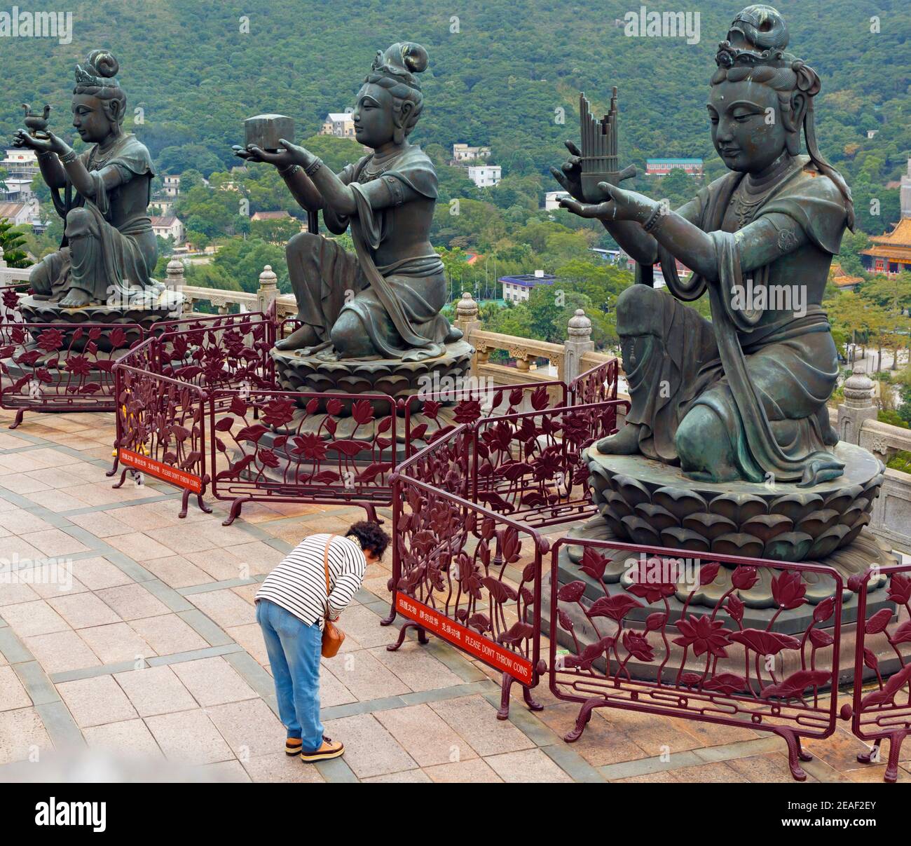 Hongkong, China. Das Buddhistische Po Lin Kloster, Lantou Insel. Verehrer, der sich vor Devas am Fuß der Großen Buddha Statue beugt. Alles in allem gibt es si Stockfoto