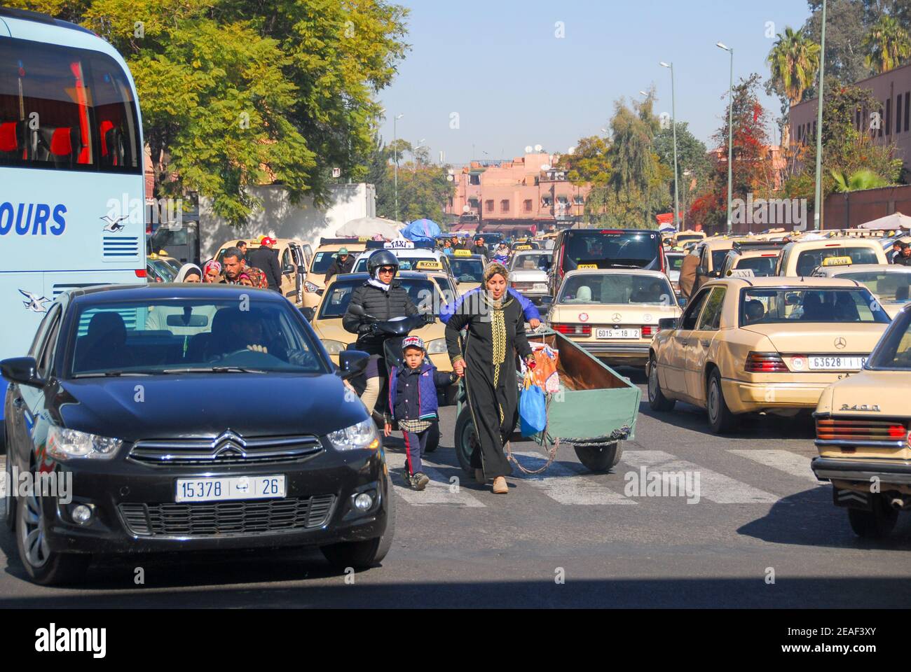 Marokkanische Frau und Kind zu Fuß durch Stau, in der Nähe von Jemaa el Fna  Platz, Marrakesch, Marokko. Handhaltung für Sicherheit Stockfotografie -  Alamy