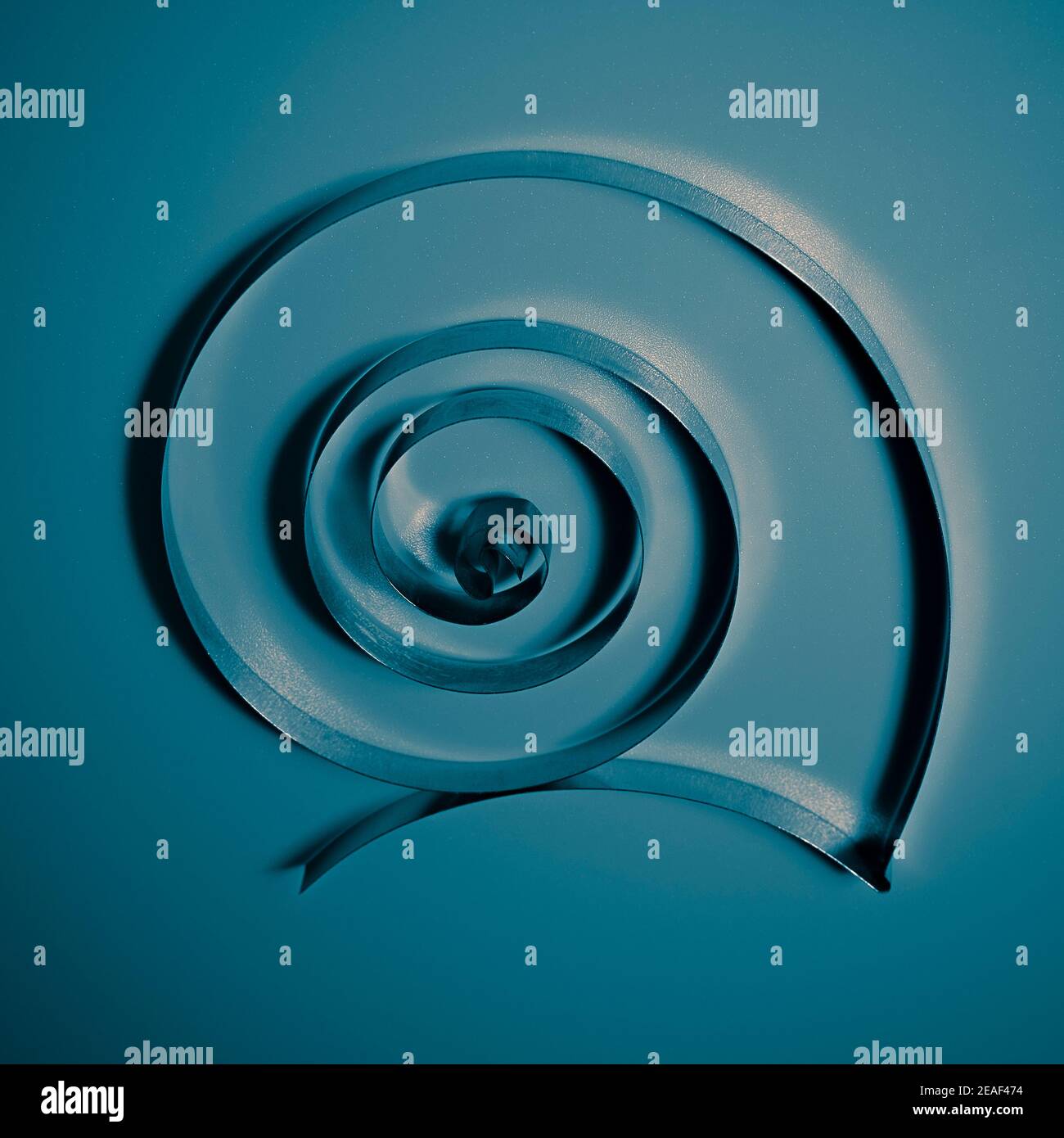 Selektives Fokusfoto der Eisenspirale auf blauem Hintergrund Stockfoto