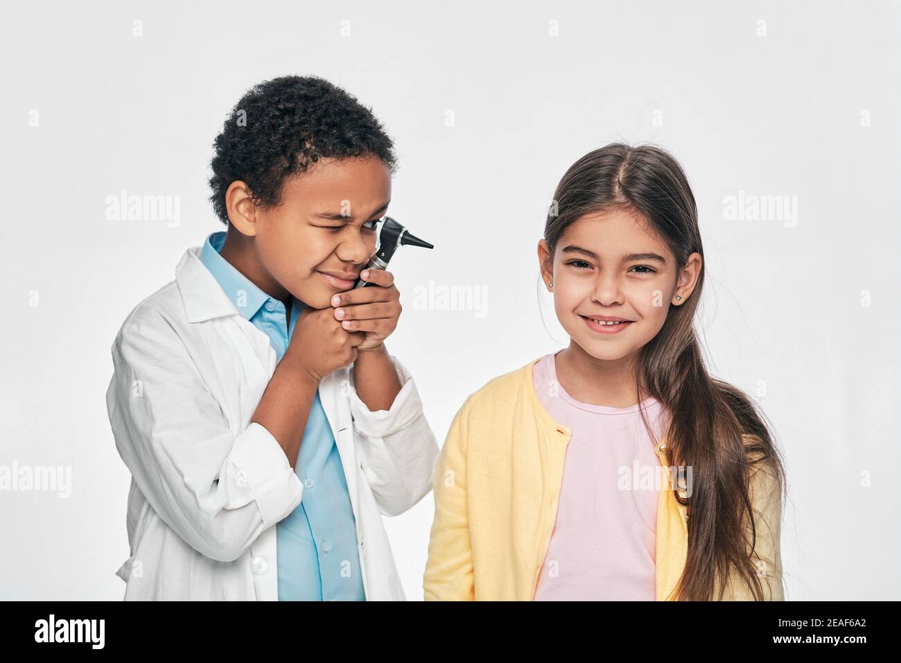 African American junge tun Ohr Prüfung asiatische Mädchen verwendet ein Otoskop. Hörtest für Kinder Stockfoto