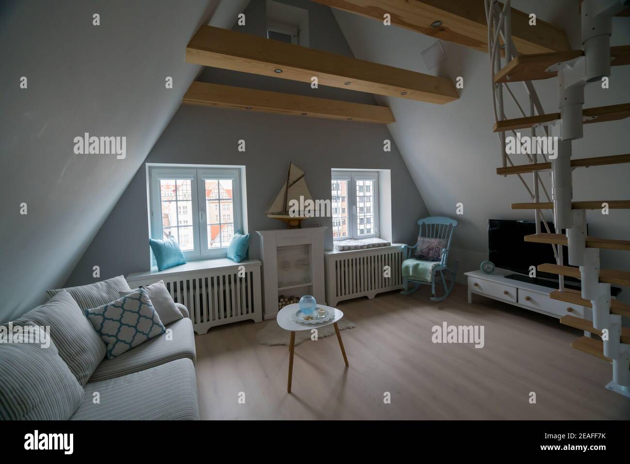 Danzig, Polen - 05,06.2017: Interieur der gemütlichen Dachwohnung im skandinavischen Stil, mit Holzmöbeln und Schaukelstuhl. Stockfoto