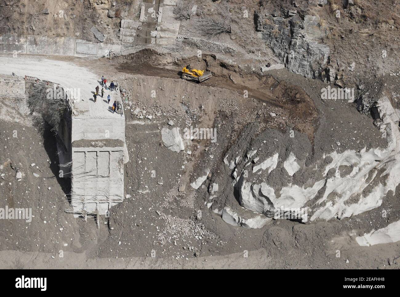 Dehradun. Februar 2021, 9th. Arbeiter rekonstruieren eine beschädigte Brücke in der Nähe des Wasserkraftprojekts Dhauliganga nach einem Gletscherausbruch im Chamoli-Distrikt im nördlichen hügeligen Bundesstaat Uttarakhand in Indien am 9. Februar 2021. Die Zahl der bisher aus den betroffenen Gebieten geborgenen Leichen ist auf 32 gestiegen, von denen noch nur sieben identifiziert werden konnten, bestätigte ein hochrangiger staatlicher Polizeibeamter. Quelle: Str/Xinhua/Alamy Live News Stockfoto