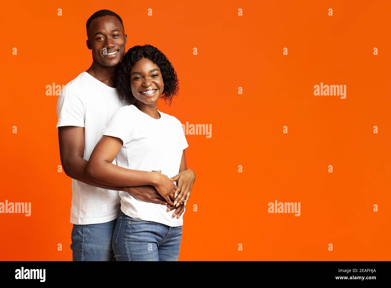 Glückliches afroamerikanisches Paar, das sich verklebte und lächelte an der Kamera Stockfoto