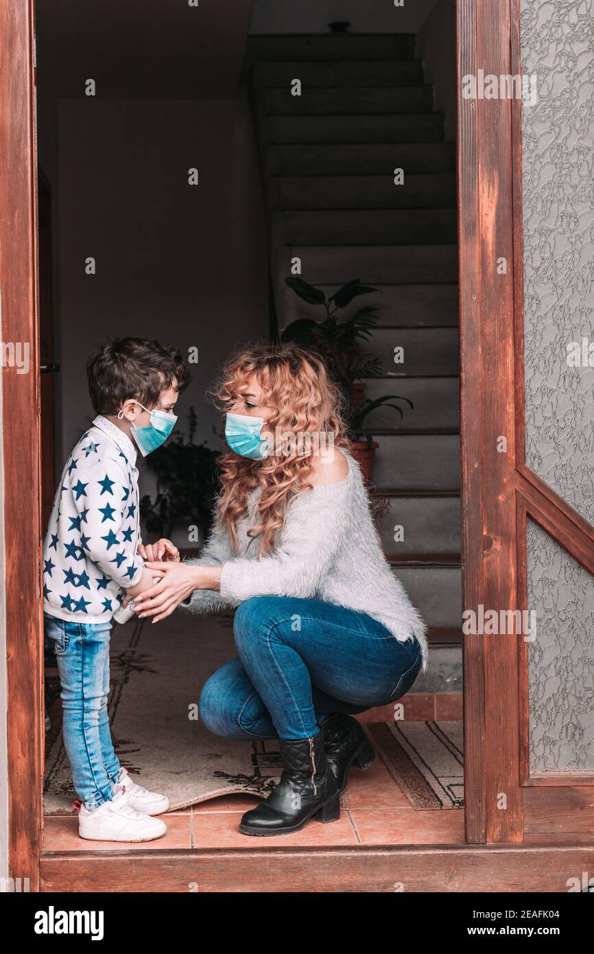 Mama und ihr Kleinkind Sohn trägt Gesichtsmasken immer bereit Zum Ausgehen Stockfoto