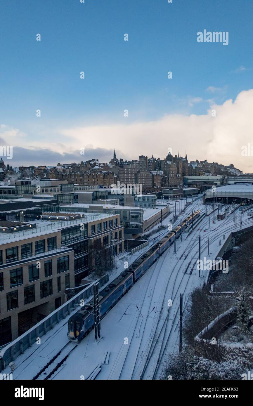 Blick auf einen Zug, der den Bahnhof Waverley in Edinburgh verlässt Nach einem Schneesturm Stockfoto
