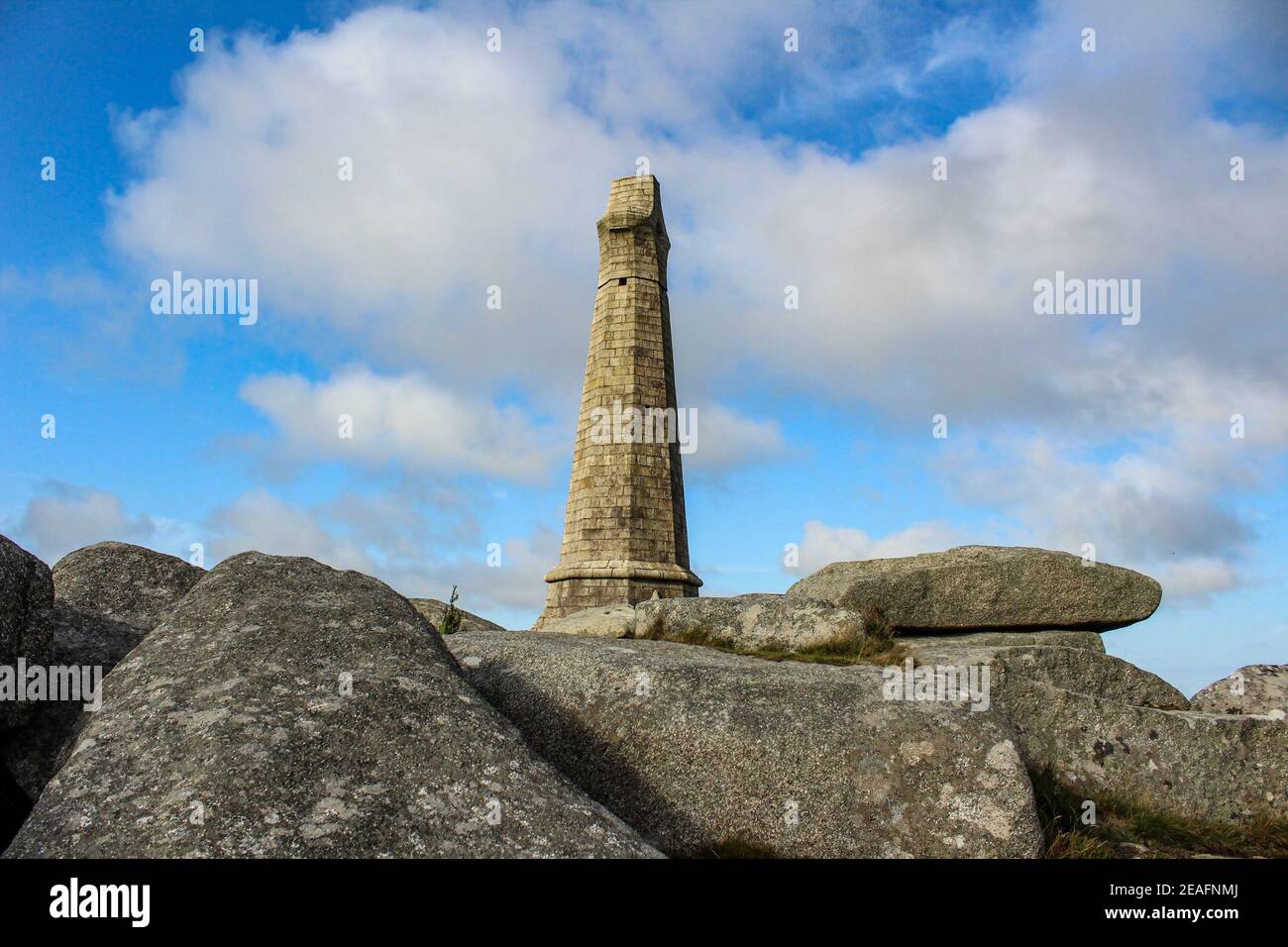 Carn Brea Monument in Camborne, Cornwall mit Felsen im Vordergrund. Es ist eine Hommage an Francis Basset und stellt die Bergbaugeschichte der Stadt dar. Stockfoto